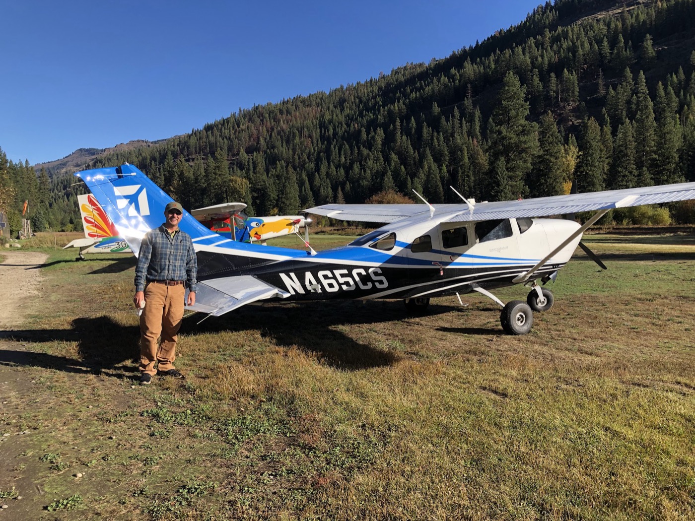 Brent Neely beside his Cessna on a grass strip